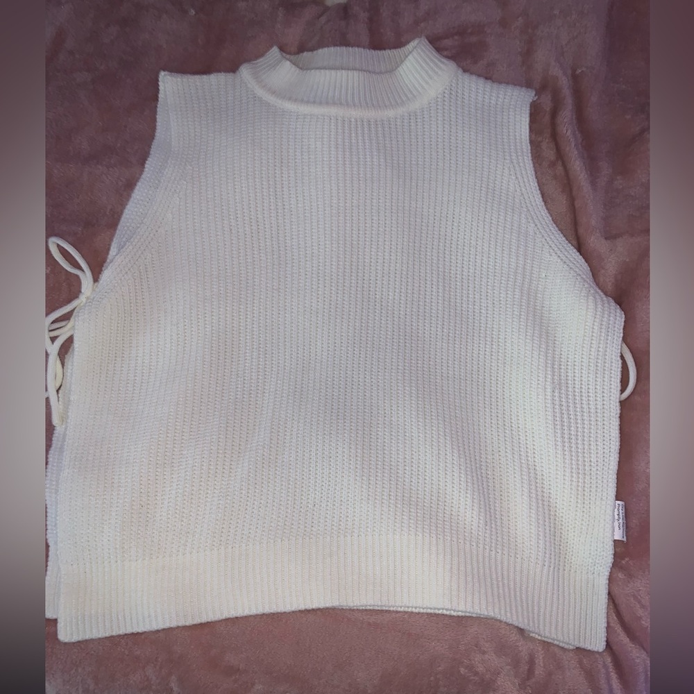Sleeveless sweater with ties on the side.